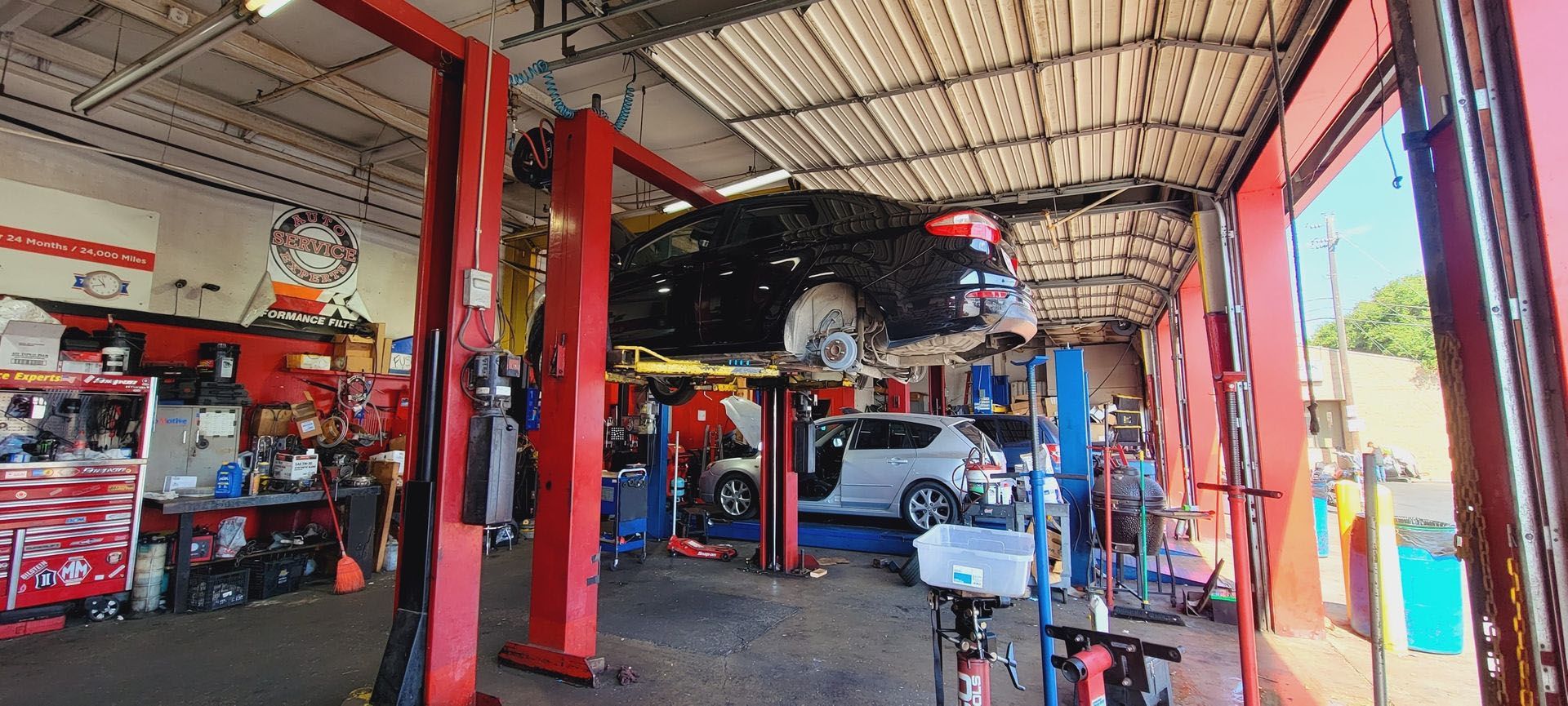 A car is sitting on a lift in a garage.