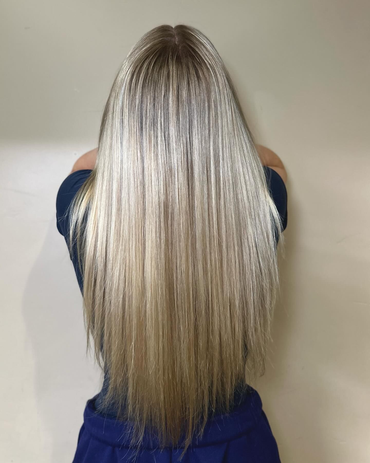 A woman with long blonde hair is wearing a blue dress.