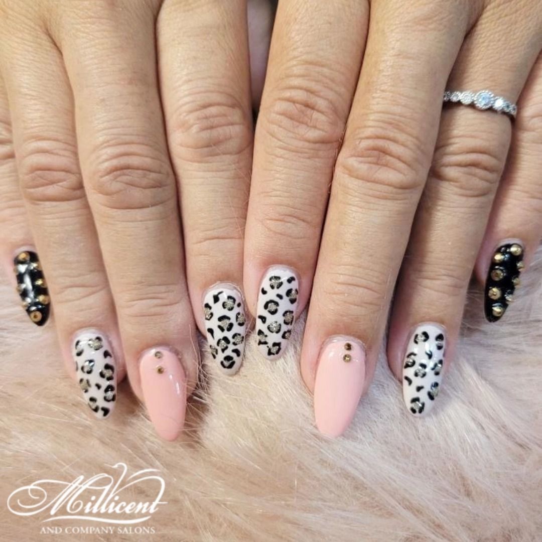 A woman 's nails are decorated with leopard print and rhinestones