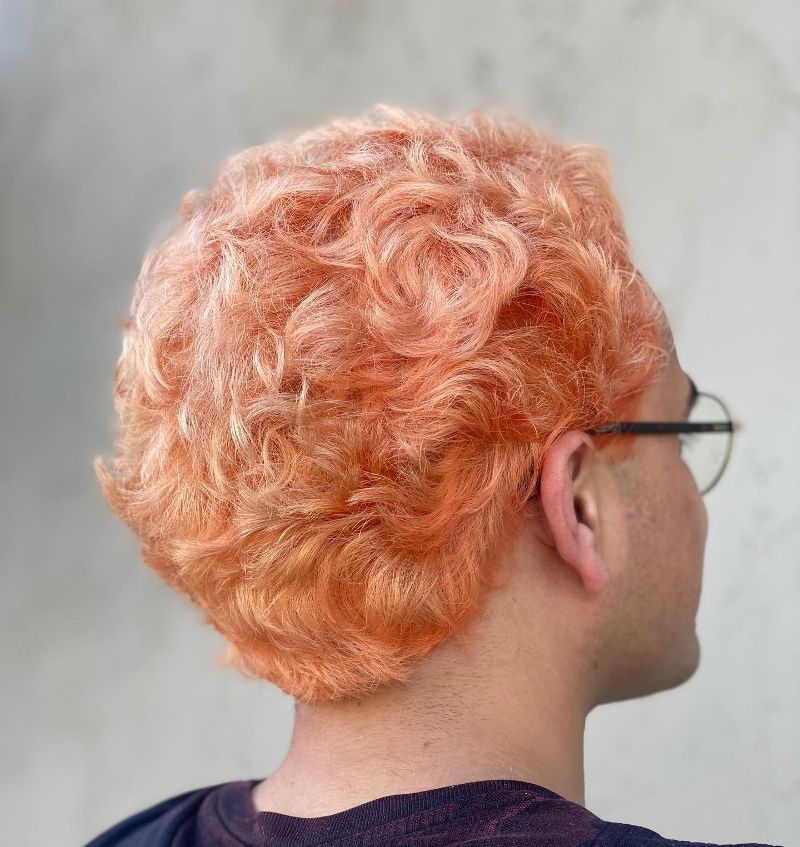A man with curly orange hair wearing glasses