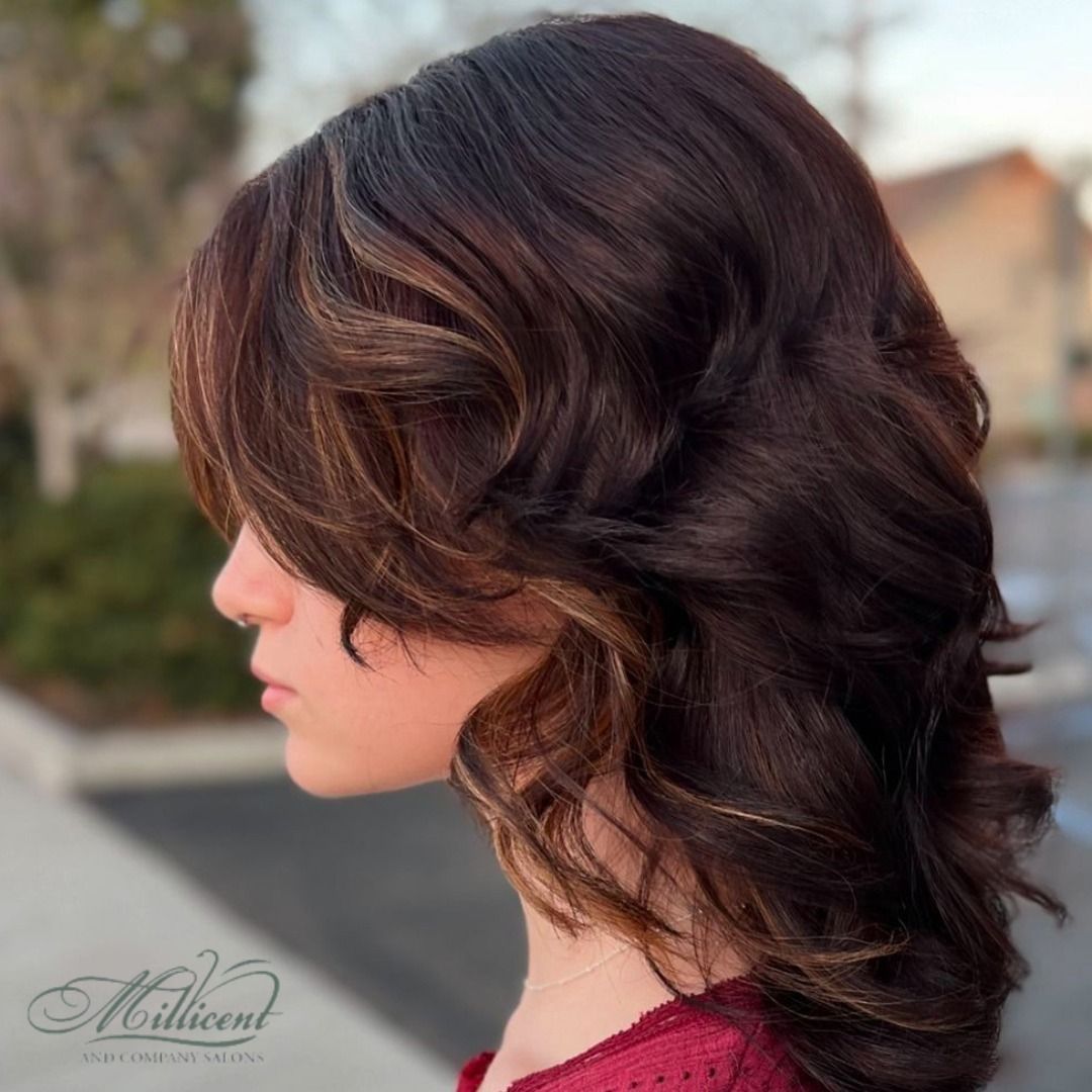 A woman with brown hair is wearing a red shirt with millicent written on it