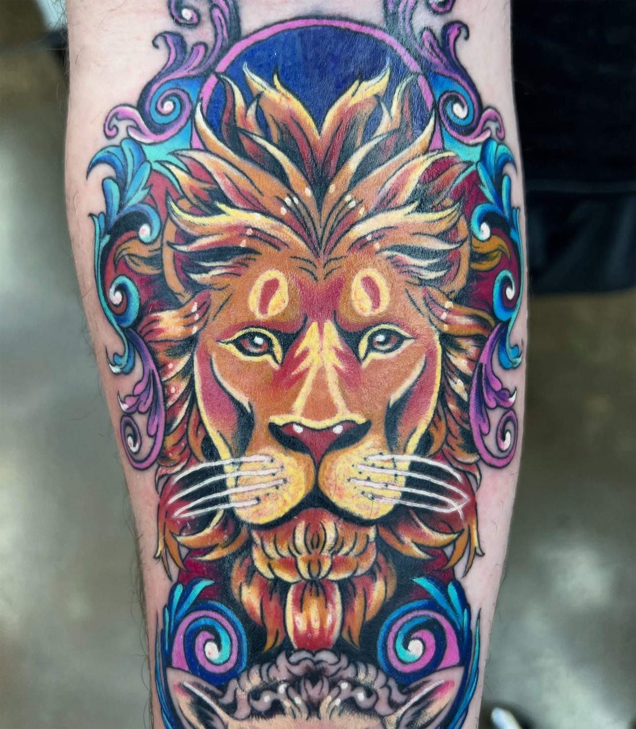 A colorful tattoo of a lion and a cat on a person 's leg