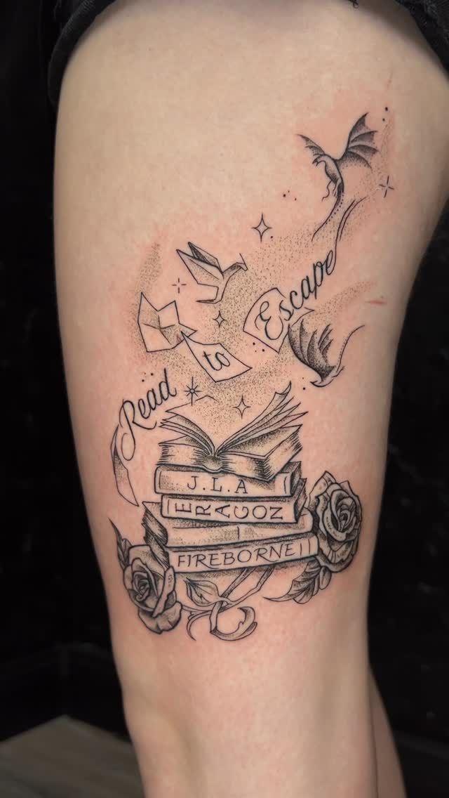 A black and white tattoo of a stack of books on a person 's leg.