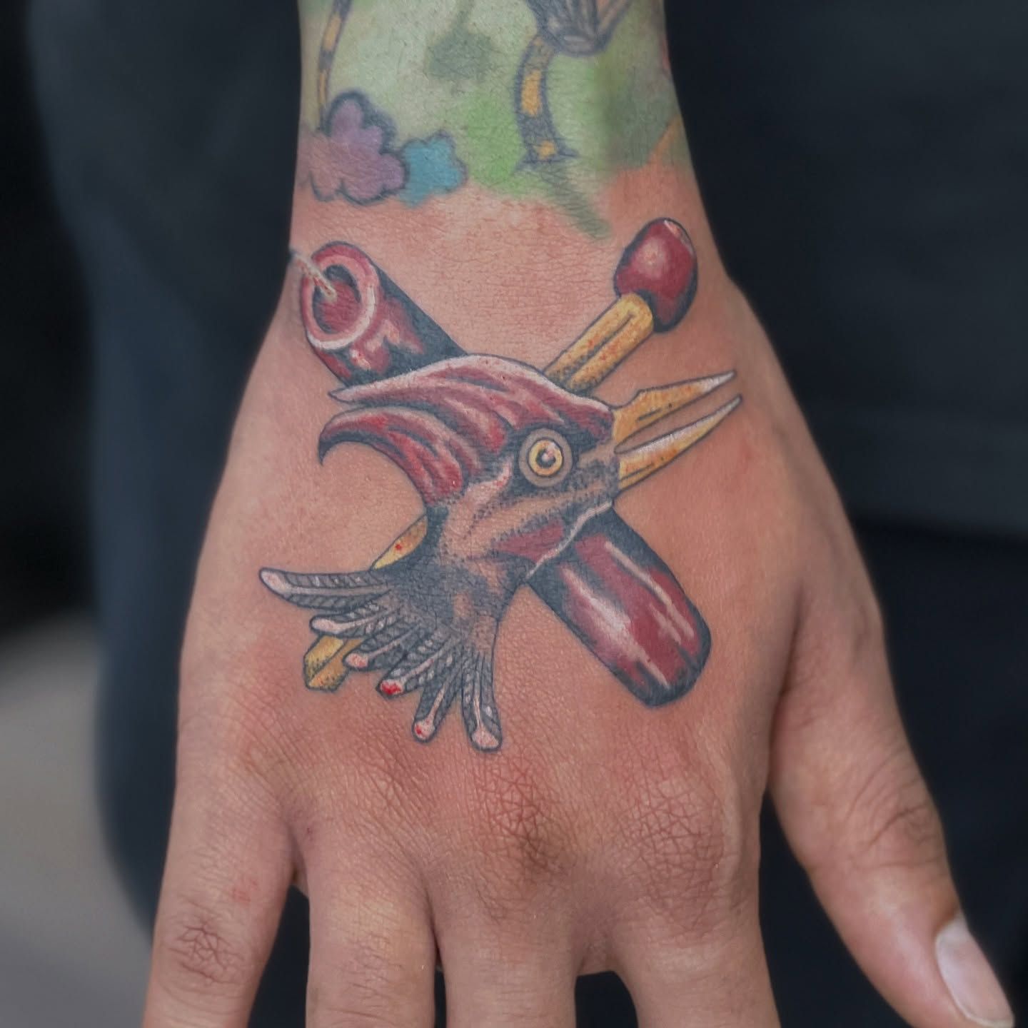 A person has a tattoo of a bird on their hand