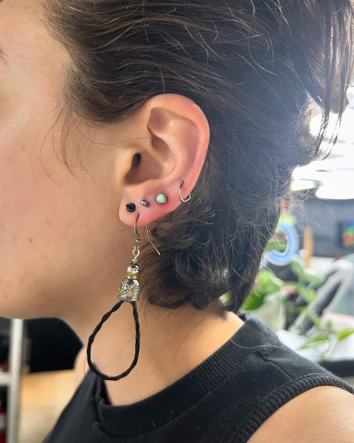 A close up of a woman 's ear with multiple piercings