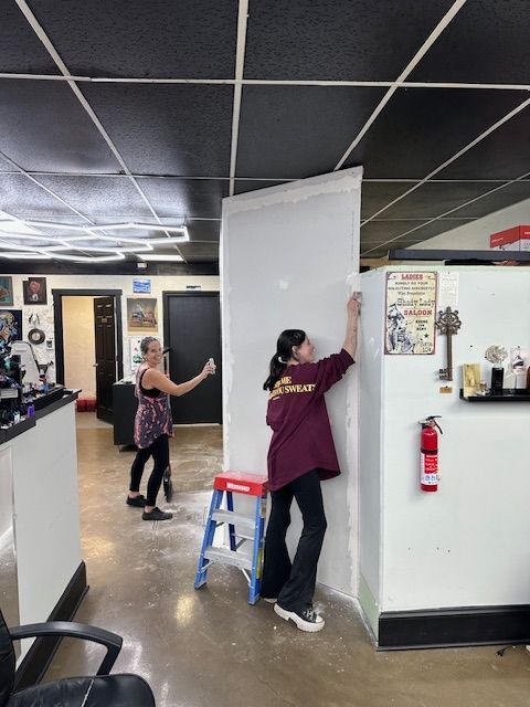 Two people install a white wall