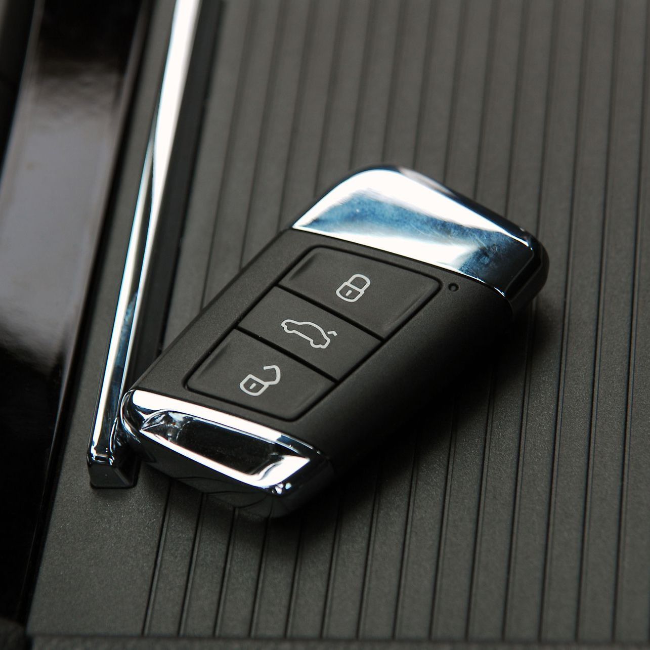 A close up of a car key on a black surface