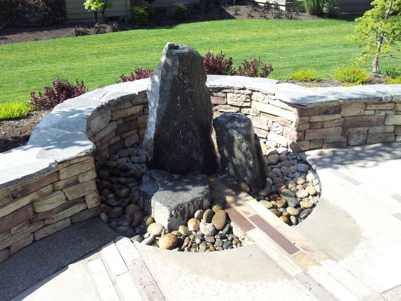 A stone wall with a fountain in the middle of it