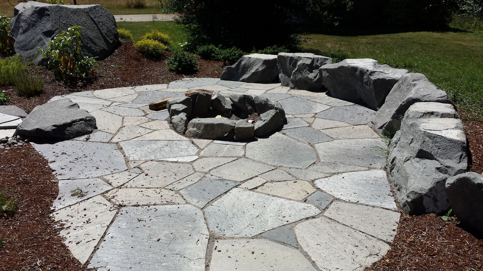 A stone patio with a fire pit in the middle
