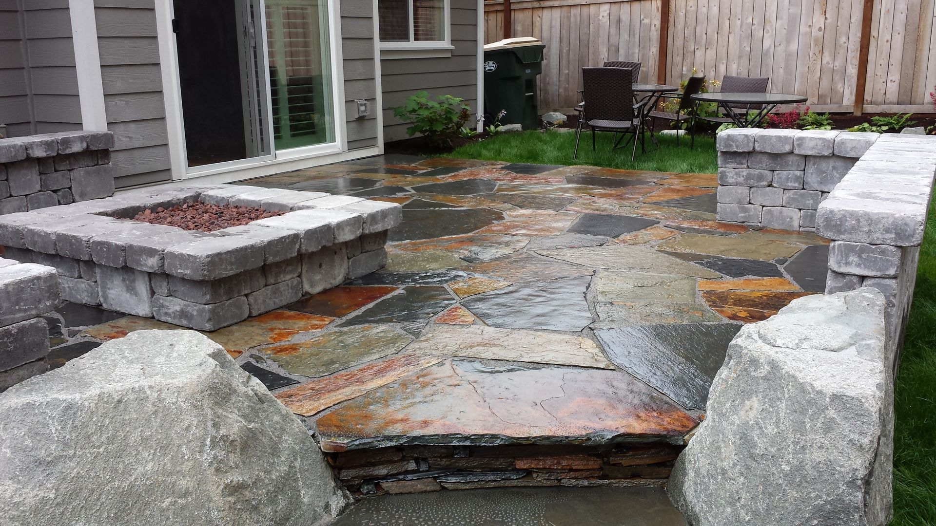 There is a fire pit in the middle of the patio.