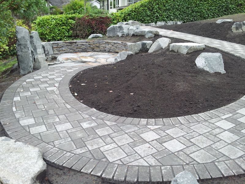 A circular walkway with bricks and rocks in a garden.