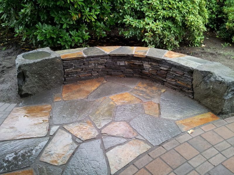 A brick walkway with a stone wall surrounding it