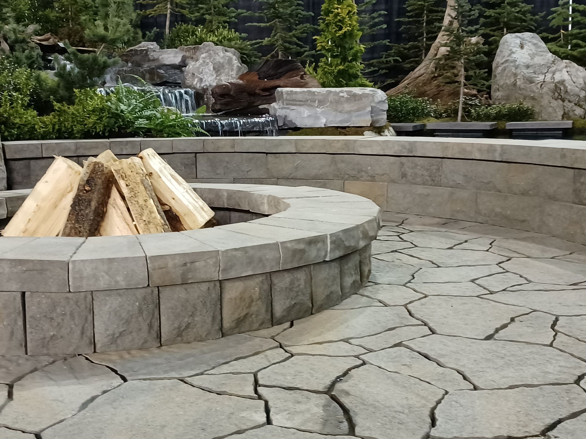 A fire pit with logs in it on a patio