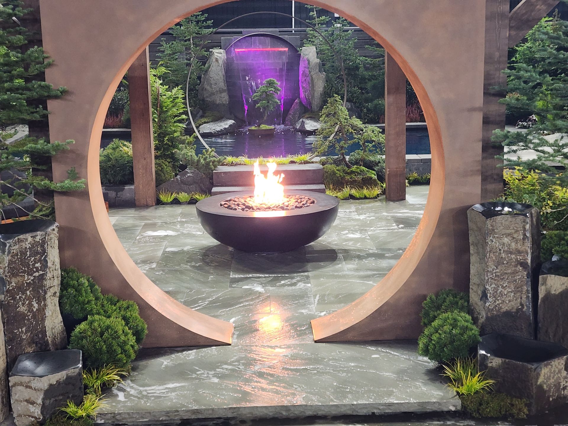 A fire pit in the middle of a circle in a garden
