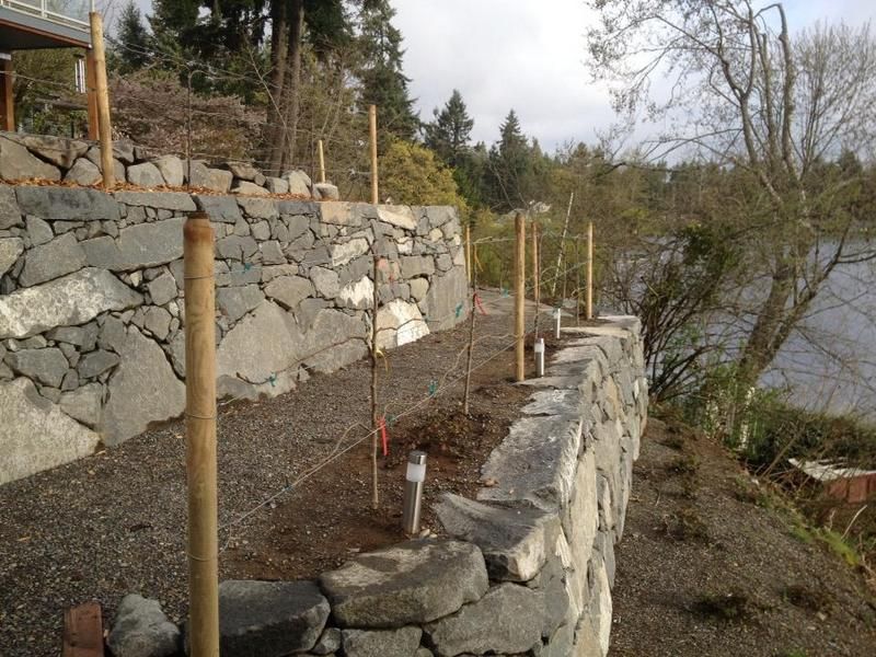 A stone wall next to a body of water