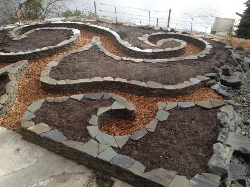 A garden with a spiral design made of rocks and dirt