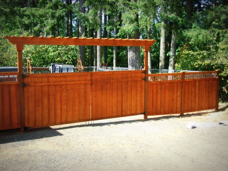 A wooden fence with a pergola on top of it