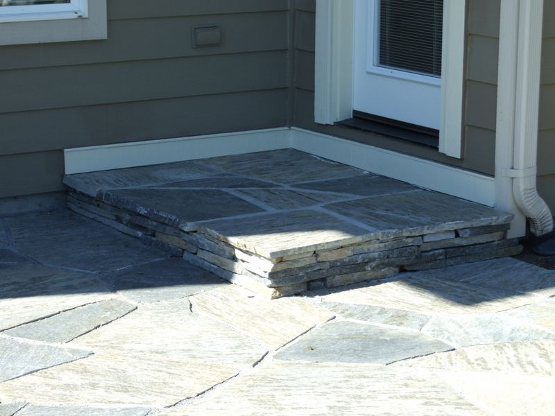 A stone walkway leading to the front door of a house.