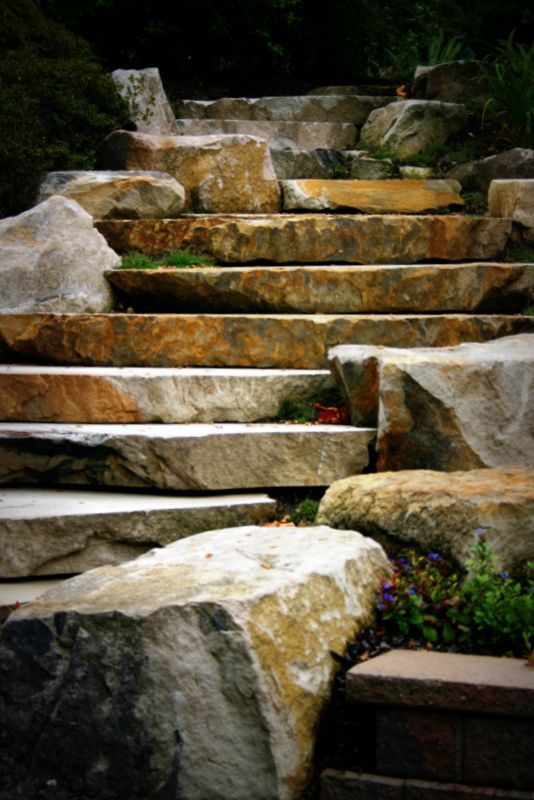 A set of stairs made of large rocks in a garden.