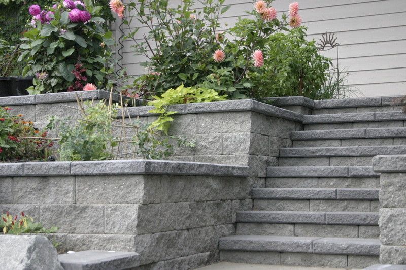 A set of stairs leading up to a house with flowers in the background.