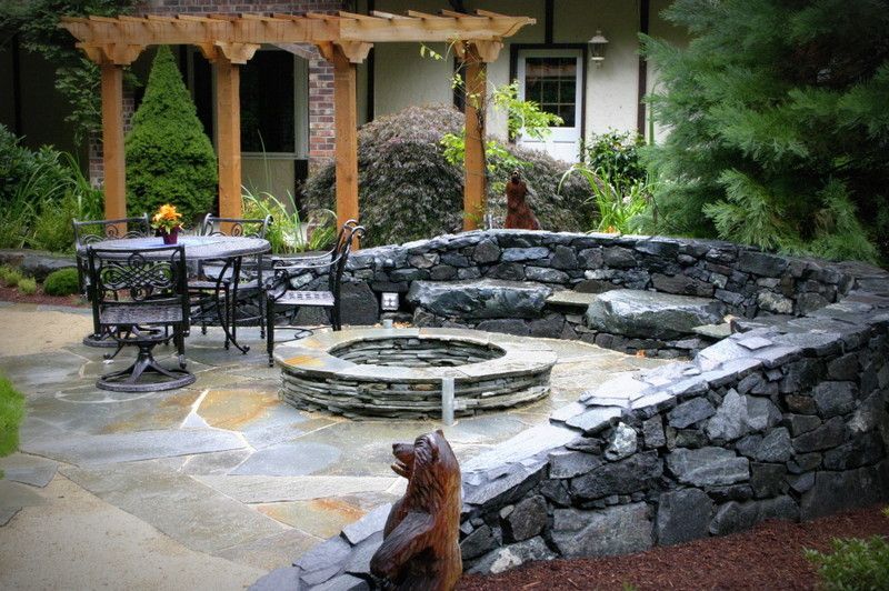 A patio with a fire pit and a statue of a bear