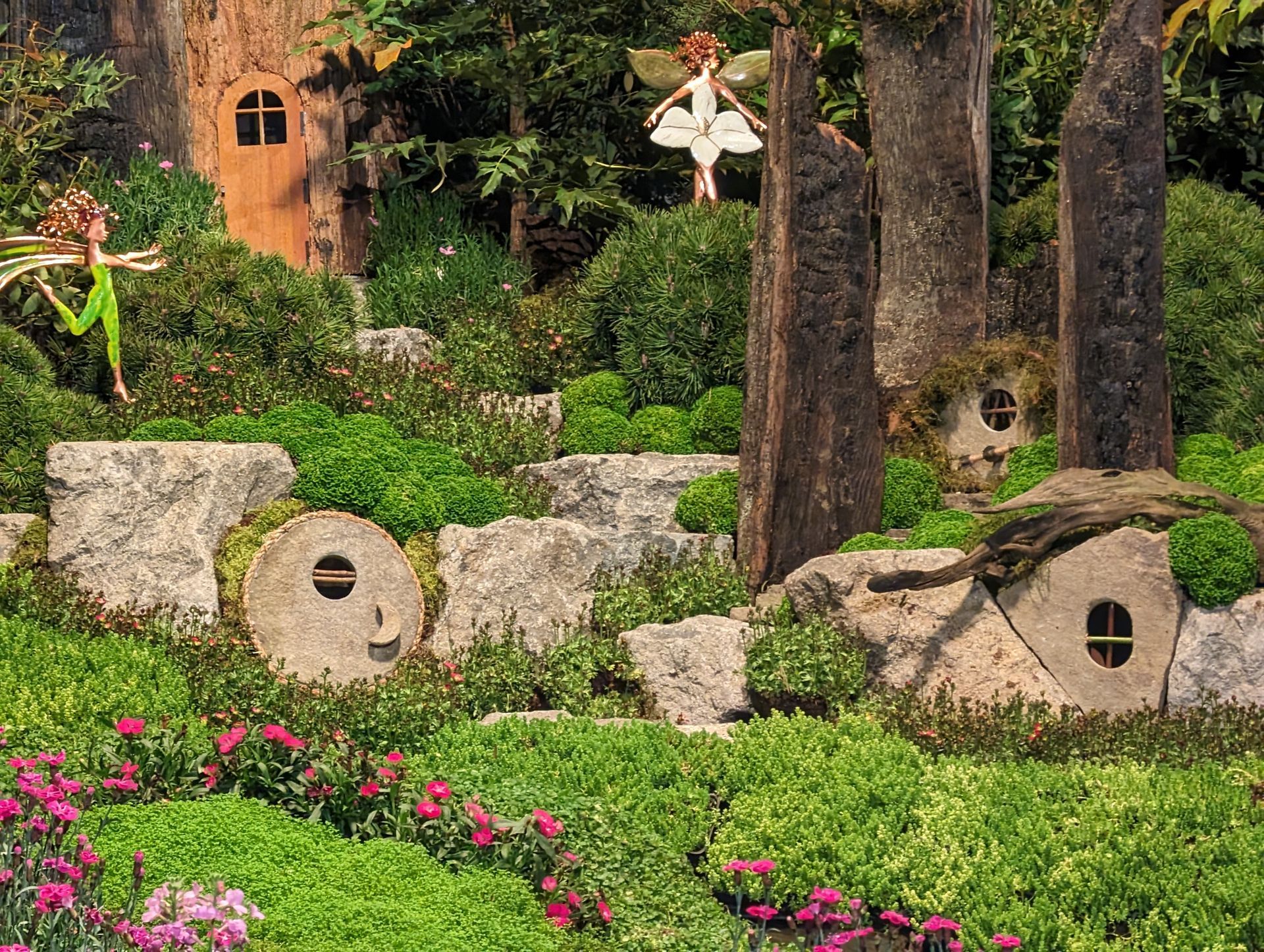A fairy is standing in the middle of a lush green forest