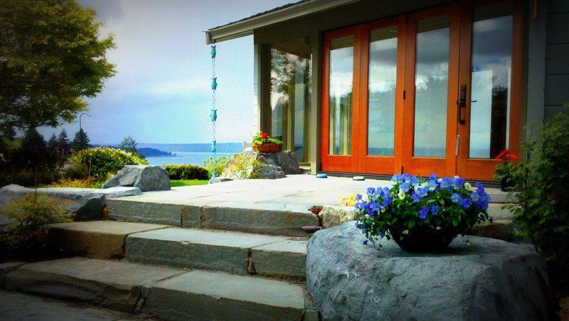 A house with a view of the ocean and a potted plant in front of it.