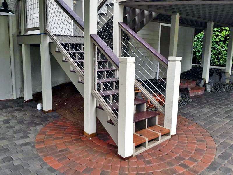 a staircase with a purple railing is surrounded by bricks