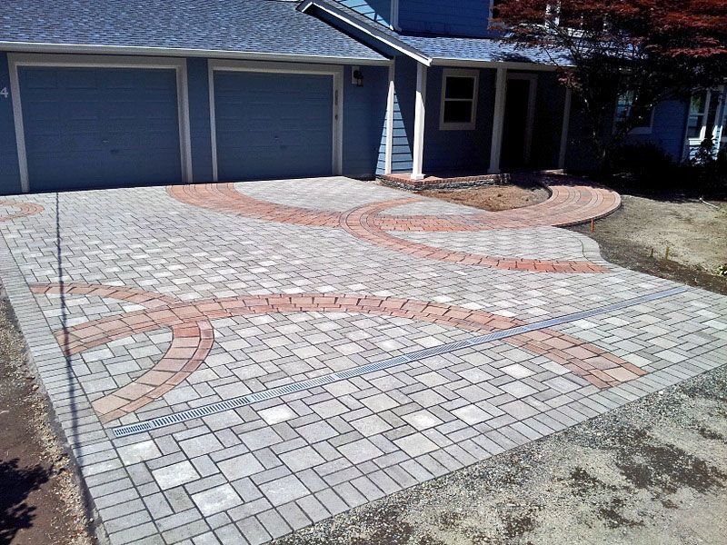 a blue house with a brick driveway in front of it