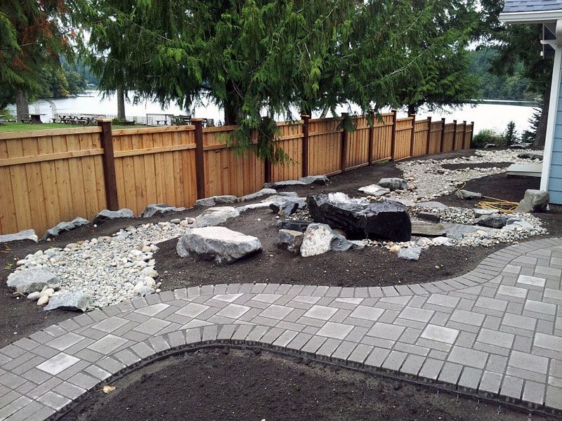a brick walkway with a wooden fence
