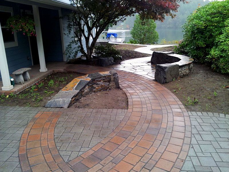 a brick walkway with a tree