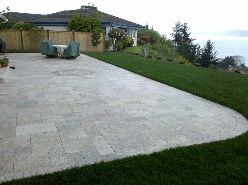 a patio with a table and chairs in front of a house