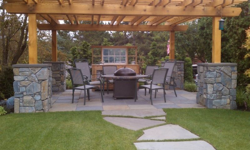 a pergola with a table and chairs underneath it