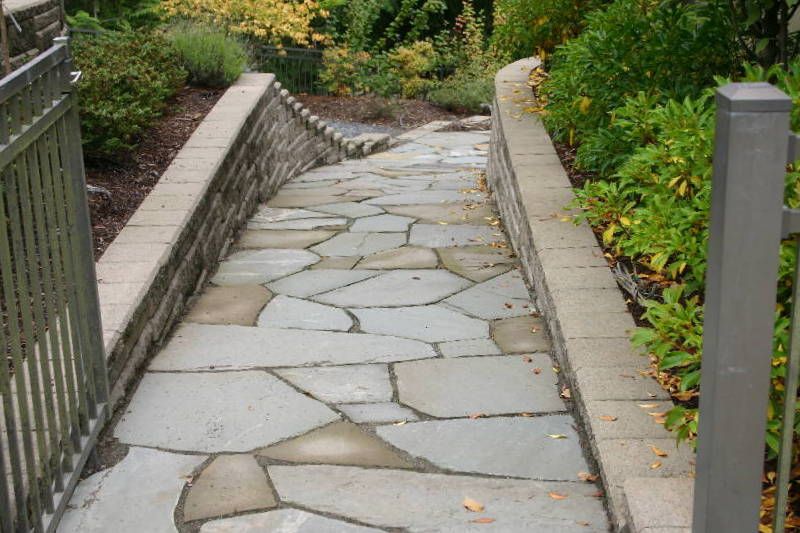 a stone walkway with a fence in the background