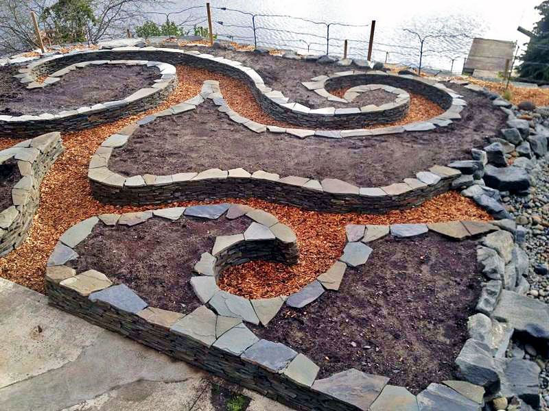 a garden with a spiral design made of rocks and soil