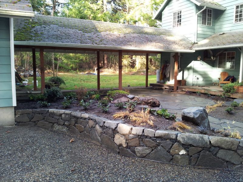 a house with a stone wall in front of it