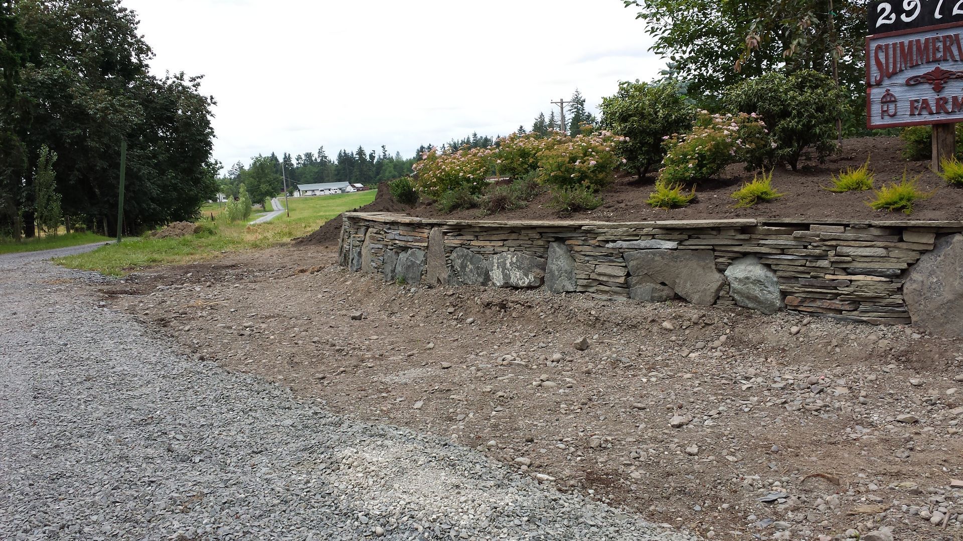 a gravel road with a stone wall
