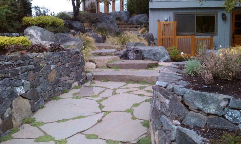 a stone walkway leading to a house with stairs