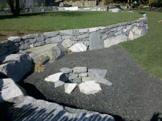 a stone wall with a circle of rocks in the middle of it