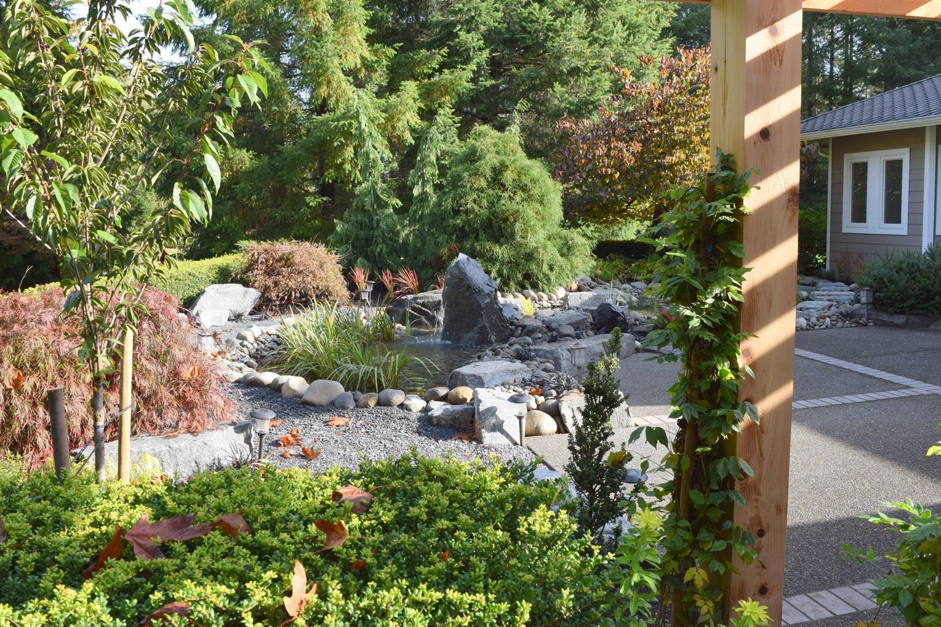 a garden with a pergola and a house in the background