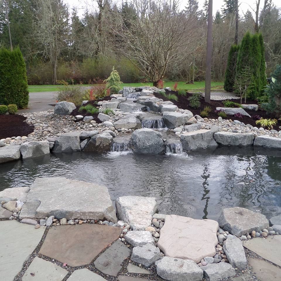 a waterfall is surrounded by rocks and trees