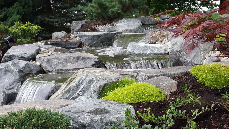 a waterfall is surrounded by rocks and trees