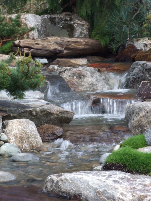 there is a small waterfall in the middle of a rocky area