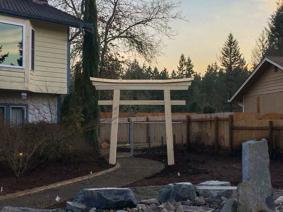a wooden torii gate in front of a house