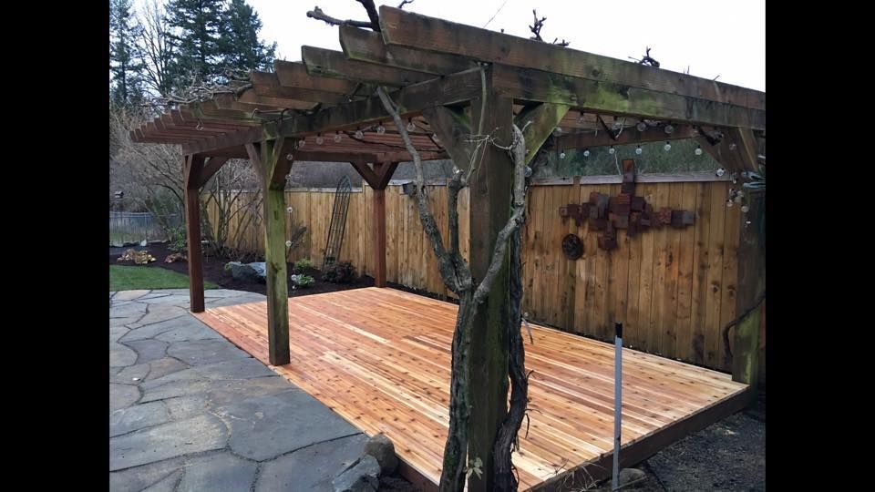a wooden pergola is sitting on top of a wooden deck