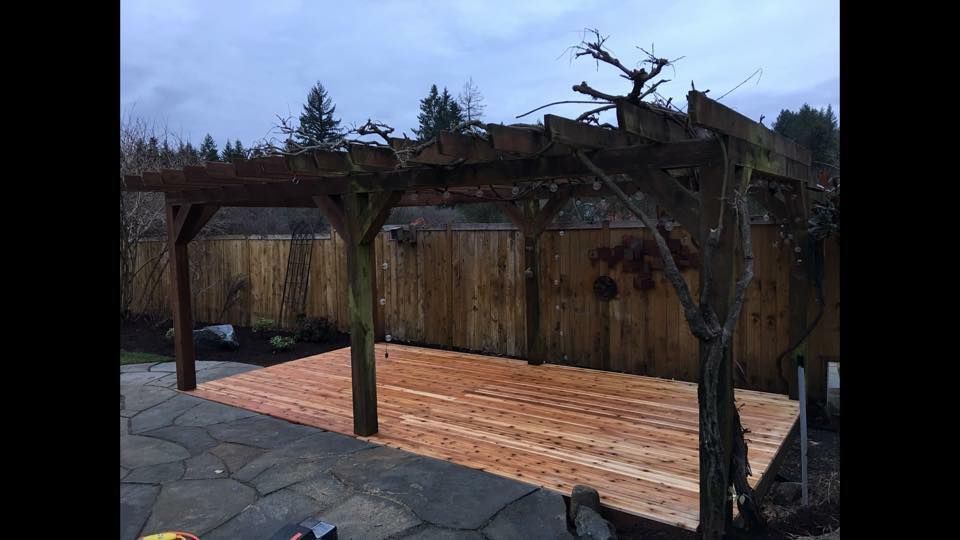 a wooden pergola is sitting on top of a wooden deck