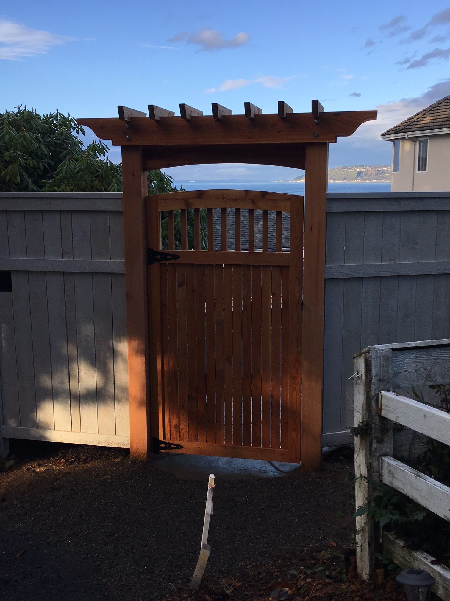 a wooden gate with a pergola on top of it