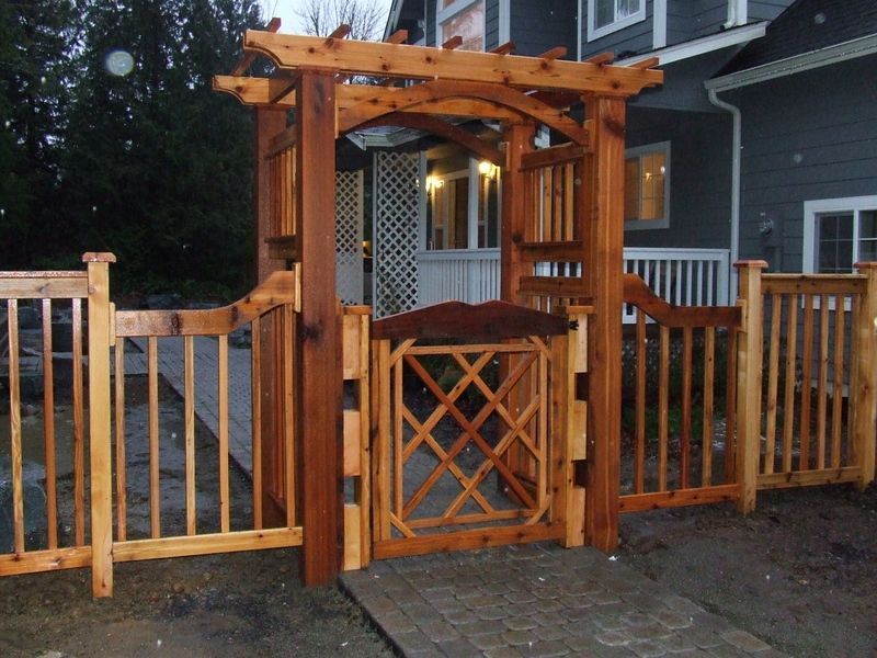 a wooden fence with a gate in front of a house