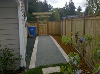 a wooden fence surrounds a walkway leading to a house