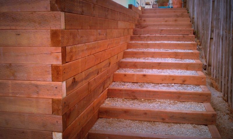 a set of wooden stairs leading up to a wooden wall